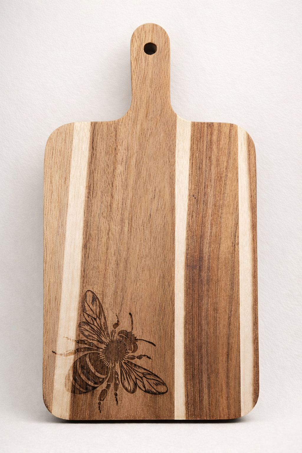 Wooden cutting board with a bee engraving on a white background
